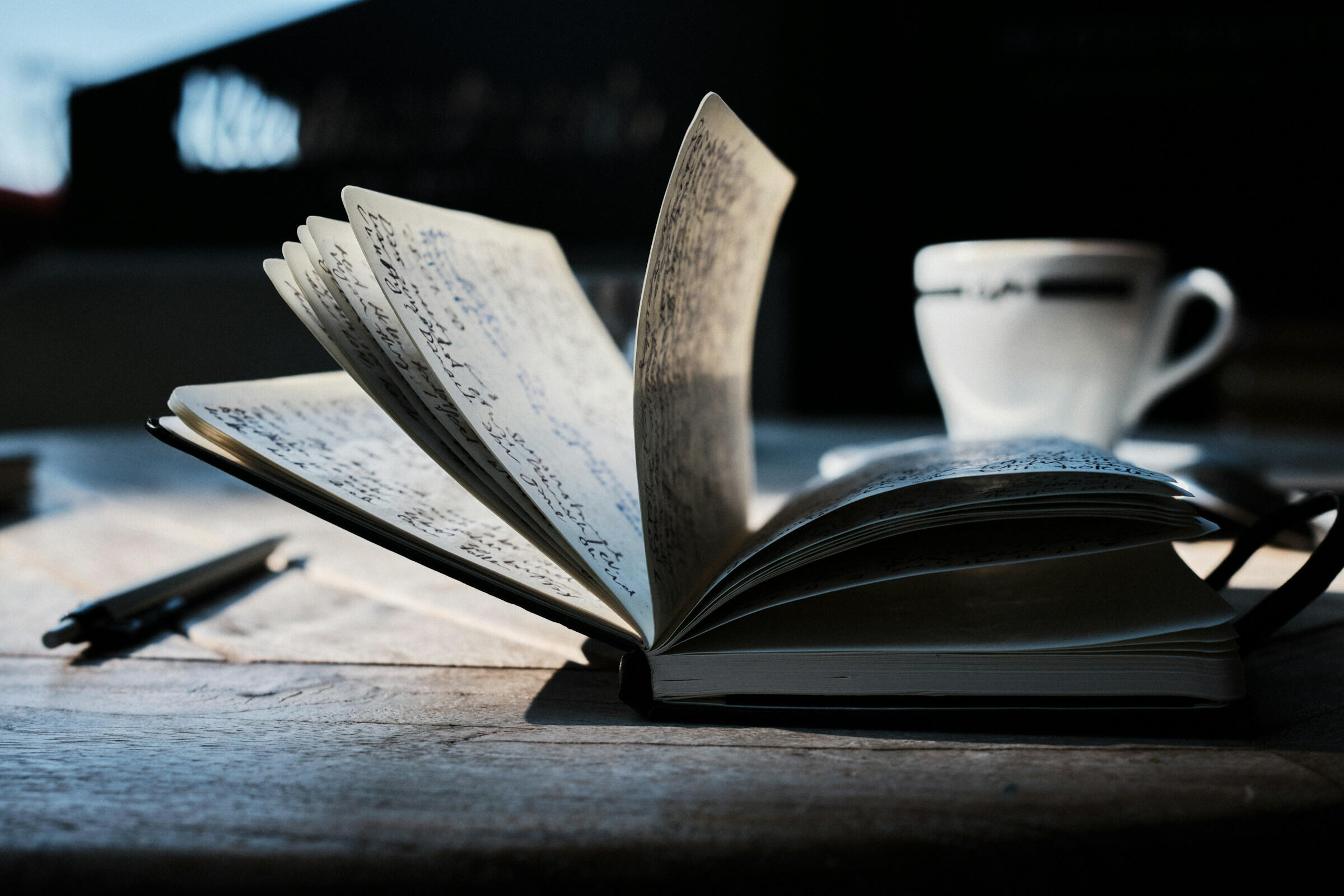 A photo of a filled journal flipping closed on a wooden table.